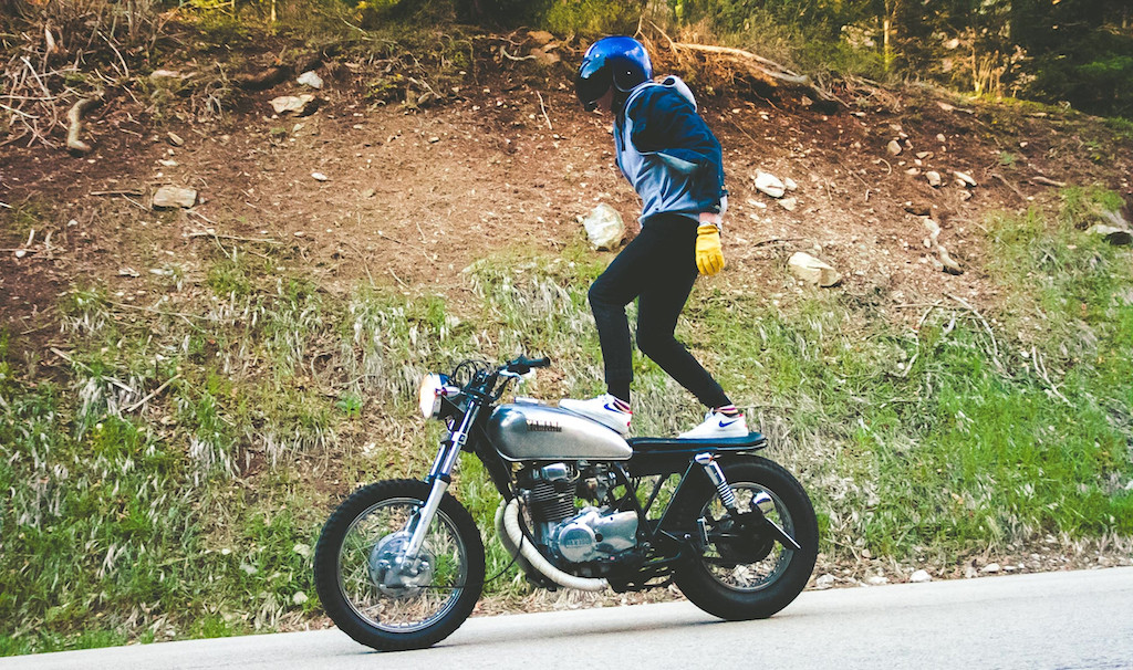 Stuntman standing on motorcycle